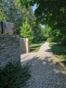White gravel path leading to the entrance of Waterlily Lodge-Stone walls
